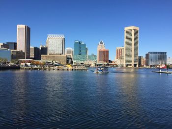 City at waterfront against blue sky