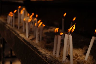 Close-up of lit candles in temple