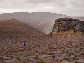 Rear view of man on mountain against sky