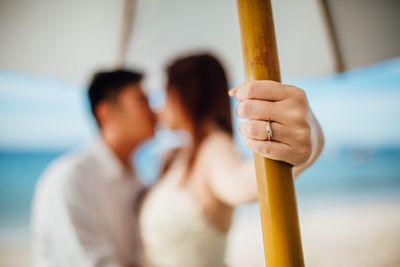 Close-up of couple kissing while standing at beach