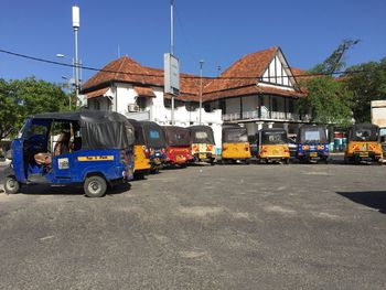 Cars on city street against sky