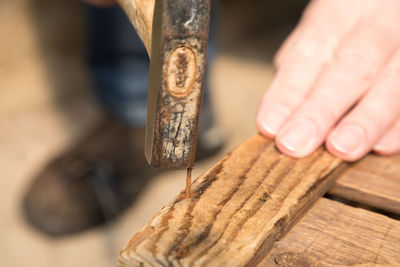 Cropped image of person holding work tool on wooden table