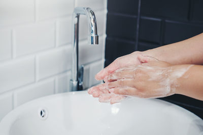 Midsection of woman in bathroom at home