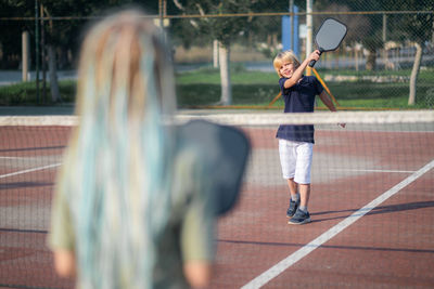 Rear view of man playing tennis