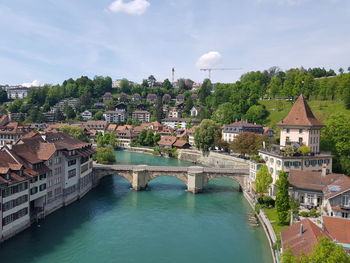 Arch bridge over river against buildings in city