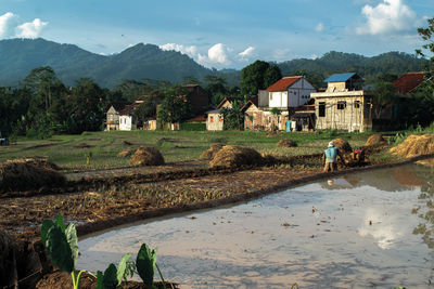 Buildings by mountain against sky