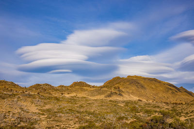 Multi-layered cloud formation over mountainous steppe landscape in patagonia, chile, south america