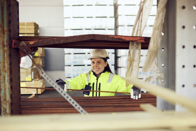 Portrait of smiling female worker in protective workwear working at industry