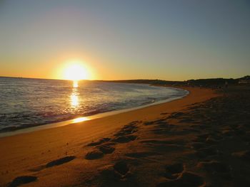 Scenic view of beach against sky during sunset