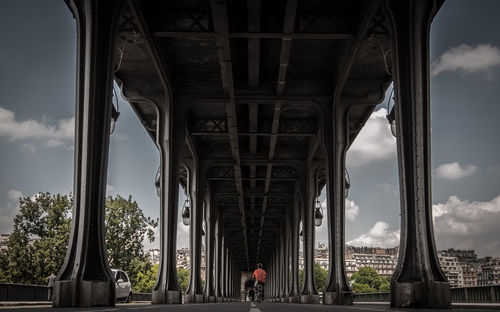 Surface level of man riding bicycle under bridge