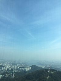 Aerial view of cityscape against blue sky