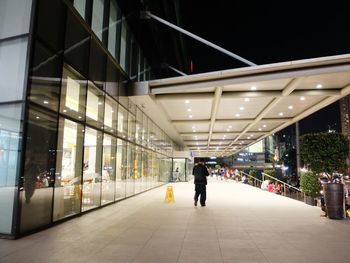 Rear view of man walking on street at night