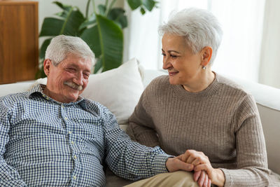 Portrait of senior man sitting on sofa at home