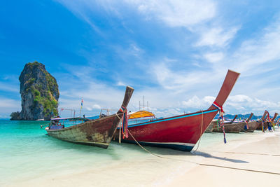 Boat moored on beach against sky