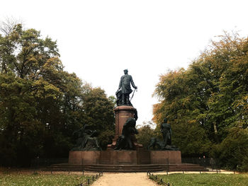 Low angle view of statue in park against clear sky