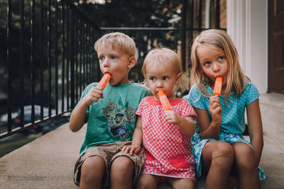 Portrait of siblings sitting on ice cream