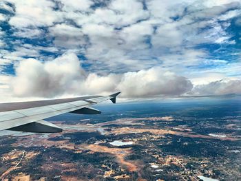 Airplane flying over landscape against sky