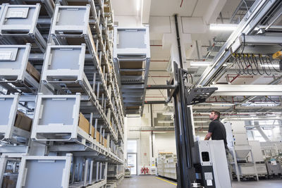 Worker operating forklift in factory warehouse