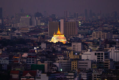 Statue of illuminated cityscape against sky