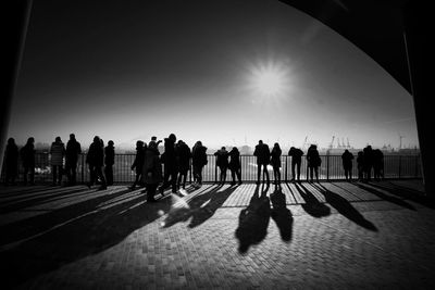 Silhouette people in town square against sky