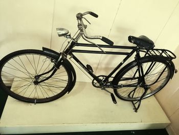 Close-up of bicycle parked against wall