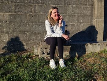 Portrait of young woman sitting on field