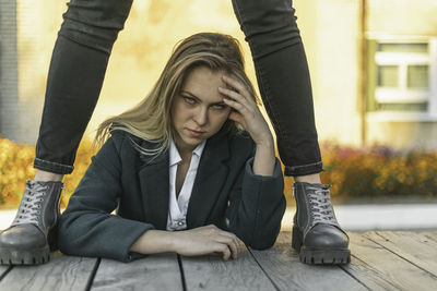 A young caucasian woman with brown hair is angry. rough boots at the level of her hands