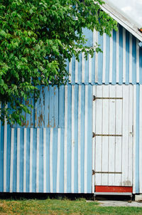 Fence on field by tree. old traditional wooden building 