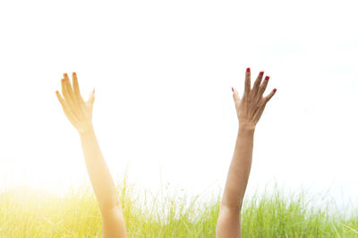 Cropped image of hands against clear sky