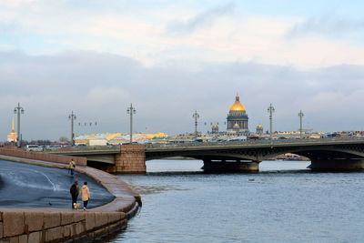 Blagoveshchensky bridge over neva river with saint isaac cathedral against cloudy sky