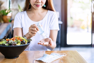Midsection of woman holding food on table