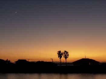 Silhouette palm trees against sky during sunset