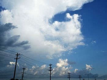 Low angle view of silhouette electricity pylon against sky