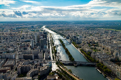 Aerial view of seine river amidst cityscape against sky