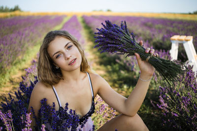 Portrait of young blonde woman enjoying lavender field.