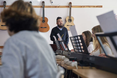 Teenagers attending keyboard lesson