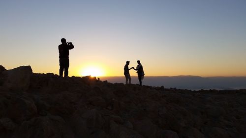 Man taking picture of couple against clear sky and mountain