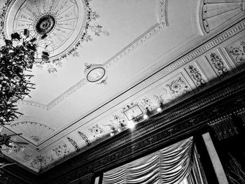 Low angle view of illuminated chandelier hanging on ceiling