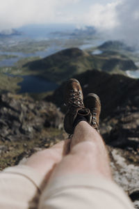 Low section of man relaxing on rock