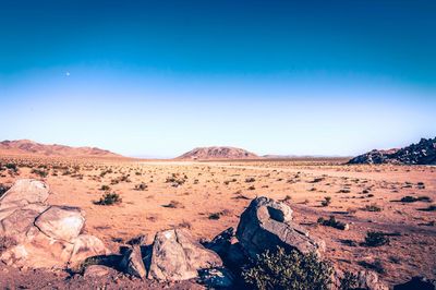 Scenic view of desert against clear blue sky