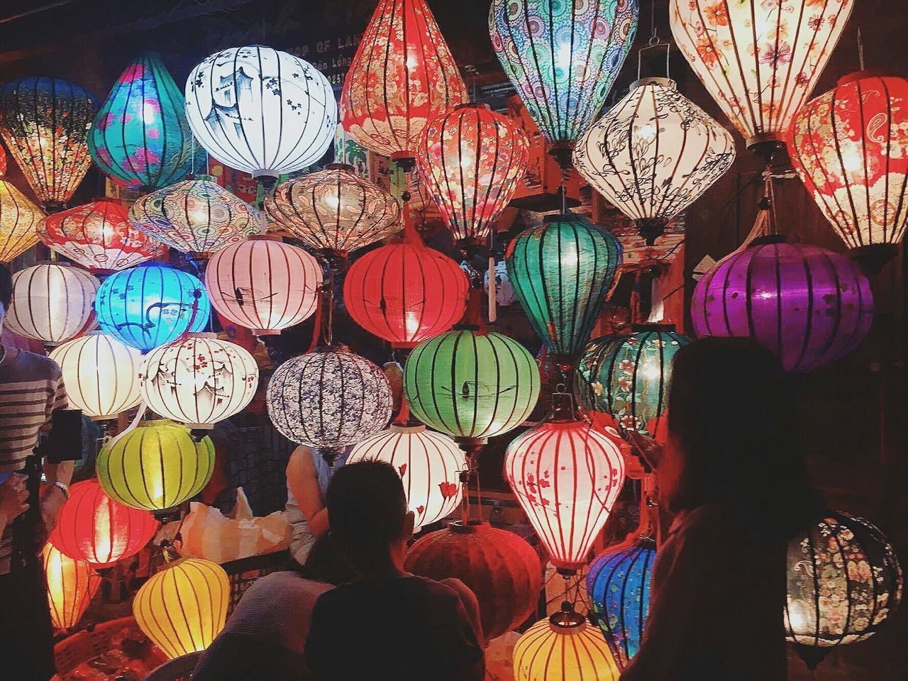 hanging, rear view, lantern, cultures, lighting equipment, red, place of worship, men, real people, adults only, chinese lantern, large group of people, paper lantern, chinese lantern festival, people, indoors, adult, day