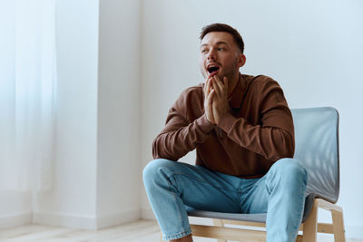 Young man sitting on sofa at home