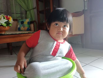 Portrait of cute girl sitting on floor at home