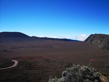 Scenic view of desert against clear blue sky