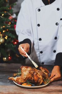 Close up master chef hands making roasted chicken in the kitchen for christmas dinner celebrating.