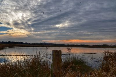 Scenic view of lake against sky during sunset