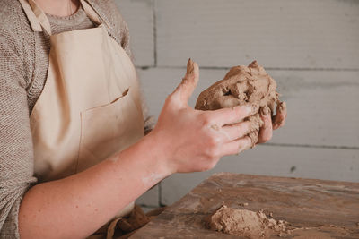 Midsection of woman holding hands on rock