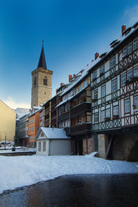 Buildings in city against sky during winter