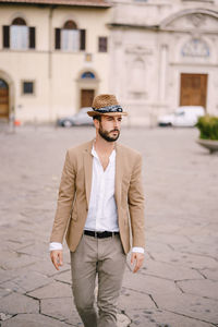 Young man wearing hat looking away on street