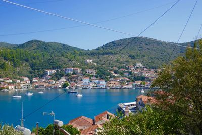 Scenic view of sea by buildings against clear blue sky